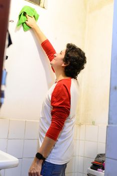 man cleaning white wall before painting while renovating interior