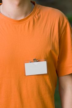 Young man wearing a blank white badge