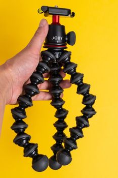 Tyumen, Russia-June 21, 2021: Flexible tripod Joby. Equipment for recording movies on a yellow background.