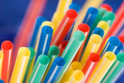 Bunch of colorful drinking straws on a bright background
