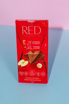 Tyumen, Russia-August 06, 2021: Red milk chocolate with hazelnuts and apple. The Swiss company Chocolette Confectionary Latvia.