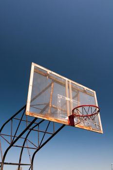 Old street Basketball hoop shot over blue sky