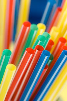 Bunch of colorful drinking straws on a bright background