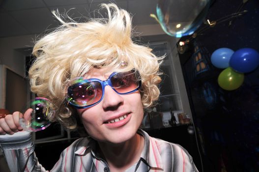 Young man wearing blond wig looks very drunk