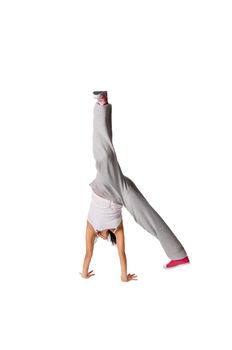 Beautiful fit girl making handstand isolated on white background