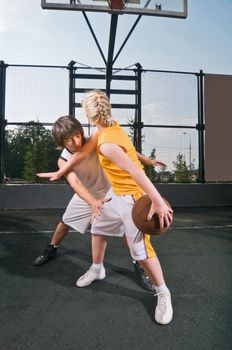 Two teenagers playing one-on-one at the streetball playground