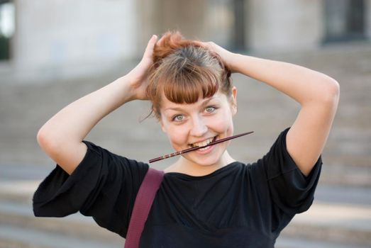 Red-haired girl fixes her hair with a hair-pin