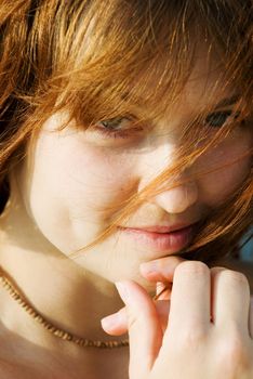 Closeup portrait of a red-haired girl with a gentle smile