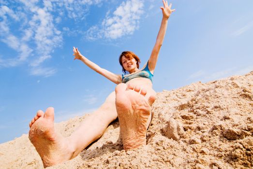 Young red haired girl having fun on a beach