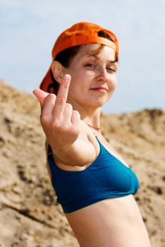 Girl in red cap showing her middle finger