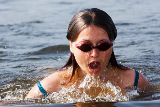 Female athlete is swimming with brass technique