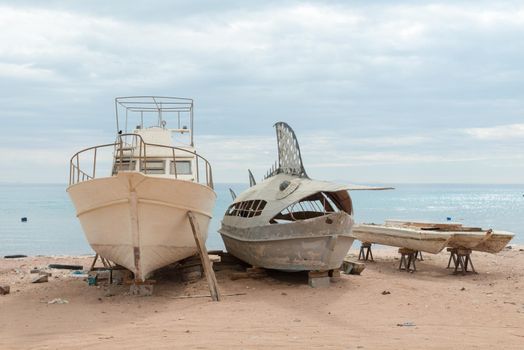 Old deserted fishing entertainment boats on the beach of Red Sea