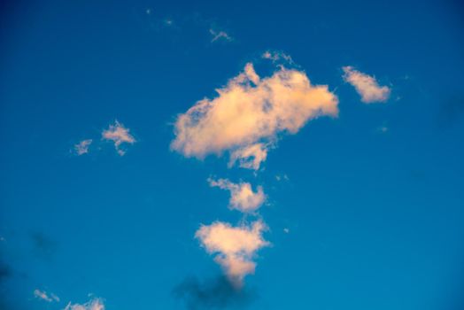 Puffy and colorful sunset clouds closeup over blue sky