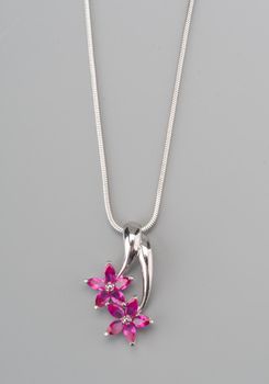 Silver pendant with rose gem shot on gray background