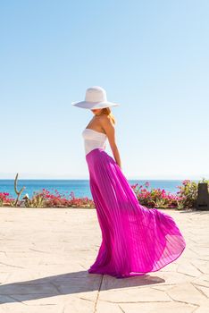 Photo of beautiful young woman in a hat at sea resort