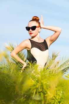 Young cool fashion woman posing over blue sky