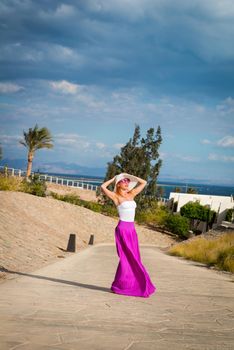 Photo of beautiful young woman in a hat at sea resort