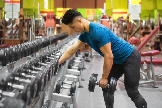 Man Exercising with Arm Weights in Gym. High quality photo