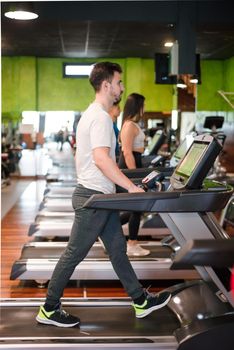 Man exercising cardio, running workout on treadmill at fitness gym. High quality photo