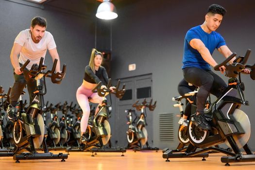 Group cycling on a modern fitness bicycle during group spinning class at the gym. High quality photo