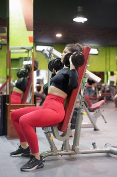 Gym woman strength training lifting weights. High quality photo