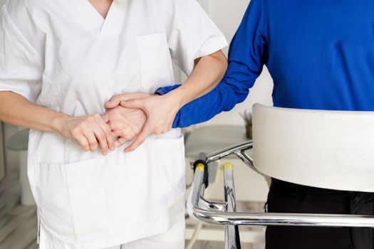 female nurse caregiver, holding patient hand, support disabled patient sit on wheelchair at hospital, young doctor carer help paralyzed patient. High quality photo