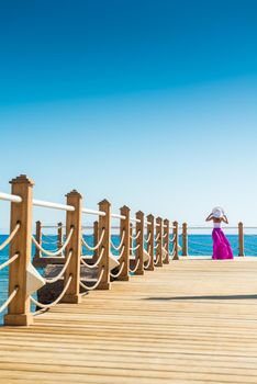 Photo of beautiful young woman in a hat at sea resort