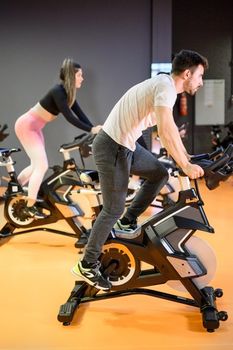 Man cycling on a modern fitness bicycle during group spinning class at the gym. High quality photo