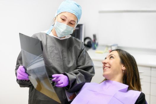 Doctor dentist showing patient's teeth on X-ray. High quality photo