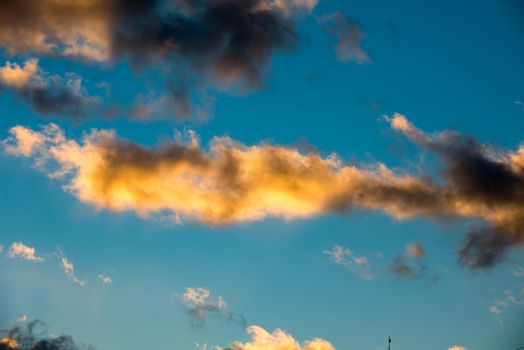 Puffy and colorful sunset clouds closeup over blue sky