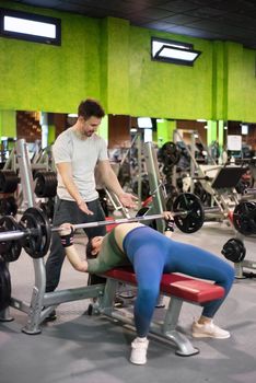 Personal trainer helping woman at gym. High quality photo