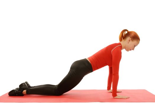 Beautiful slim red fit woman doing pushups over white background