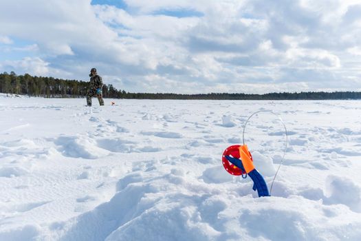 winter landscape of fishermen on the ice of the river on a sunny day. winter sports