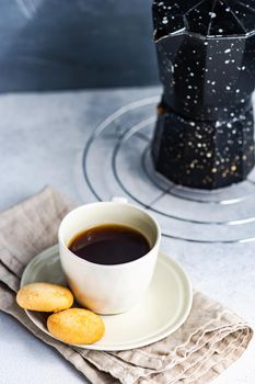 Morning cup of coffee and milk cookies served on the table