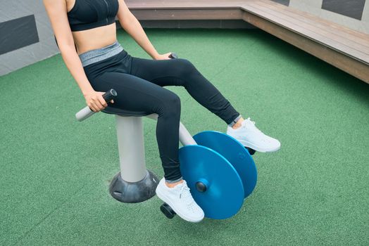 Asian woman exercising at outdoors gym playground equipment