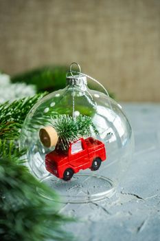 Christmas card concept with glass ball with red car carring christmas tree