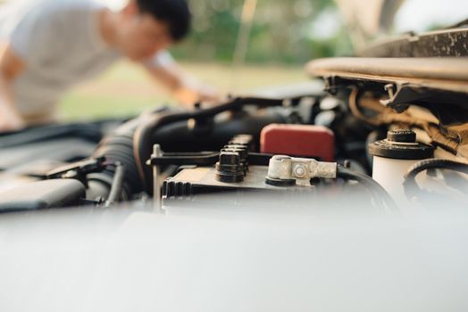 A man tries to repair the car on the road