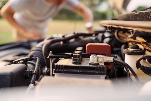 A man tries to repair the car on the road