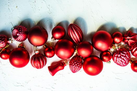 Christmas card concept with variety of holiday festive red balls on concrete background