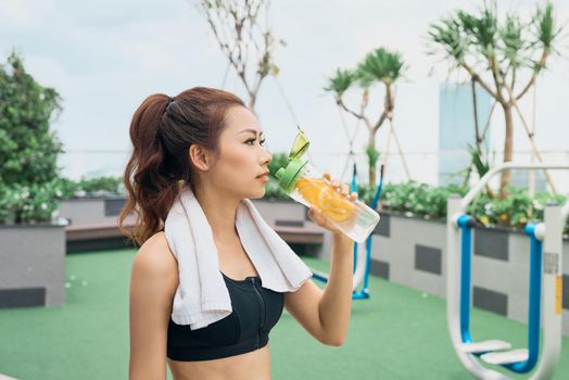 Asian woman exercising at outdoors holding water bottle