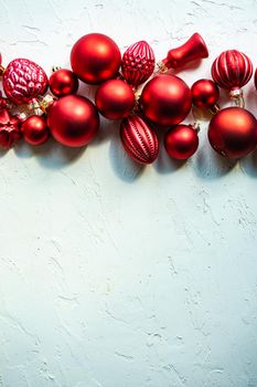 Christmas card concept with variety of holiday festive red balls on concrete background