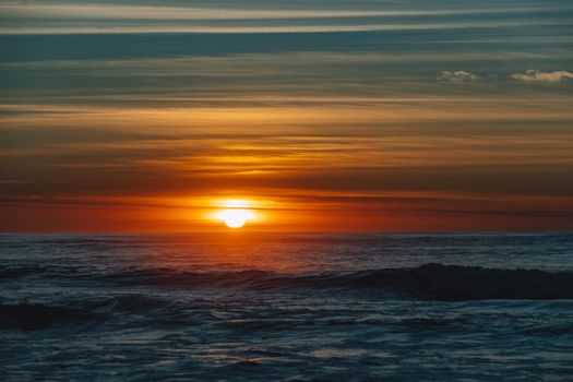 Colorful ocean beach sunrise with deep blue sky and sun rays. High quality photo