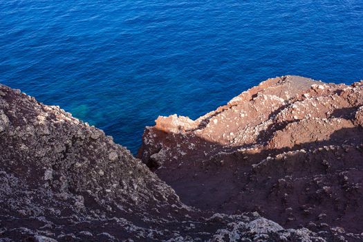 View of the scenic lava rock cliff in the Linosa island. Sicily