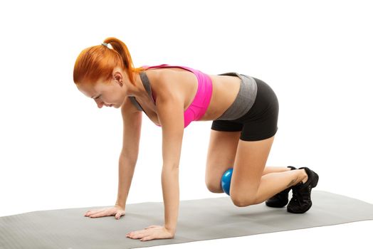 Young slim sensual red woman wearing sports bra practicing fitness