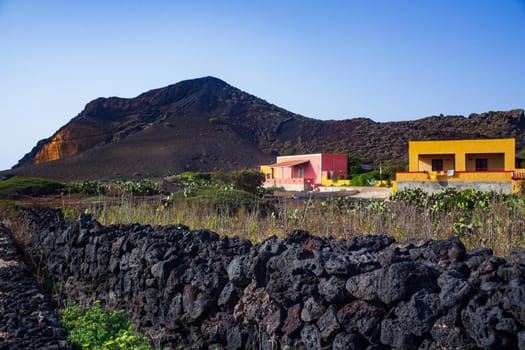 Characteristic view of Linosa with the typical colorful houses and the dry stone wall built with lava stones