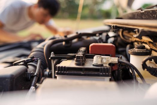 A man tries to repair the car on the road