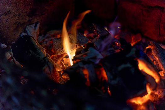 Glowing coals in a barbeque grill and a little flame. Close up