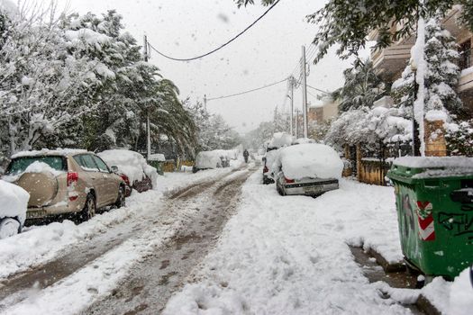 ATHENS, GREECE - February 16 2021: Cars totally covered with snow in Vrilissia district, during snow storm in Athens city, capital of Greece, Europe