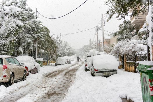 ATHENS, GREECE - February 16 2021: Cars totally covered with snow in Vrilissia district, during snow storm in Athens city, capital of Greece, Europe