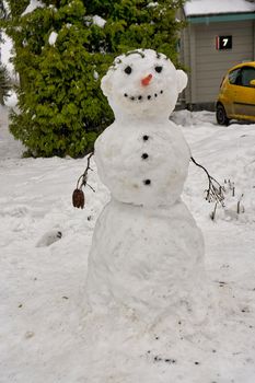 Happy snowman standing in winter christmas landscape.Snow background
